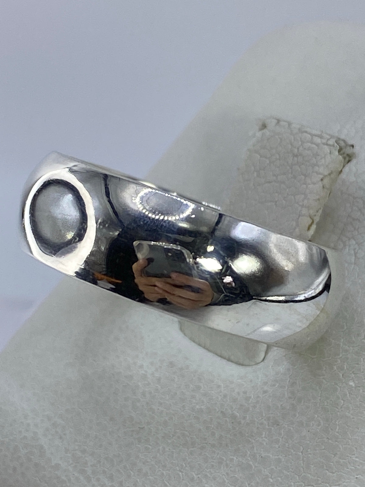 Anillo de plata en la mano mostrando el acabado pulido y el Quinto 925