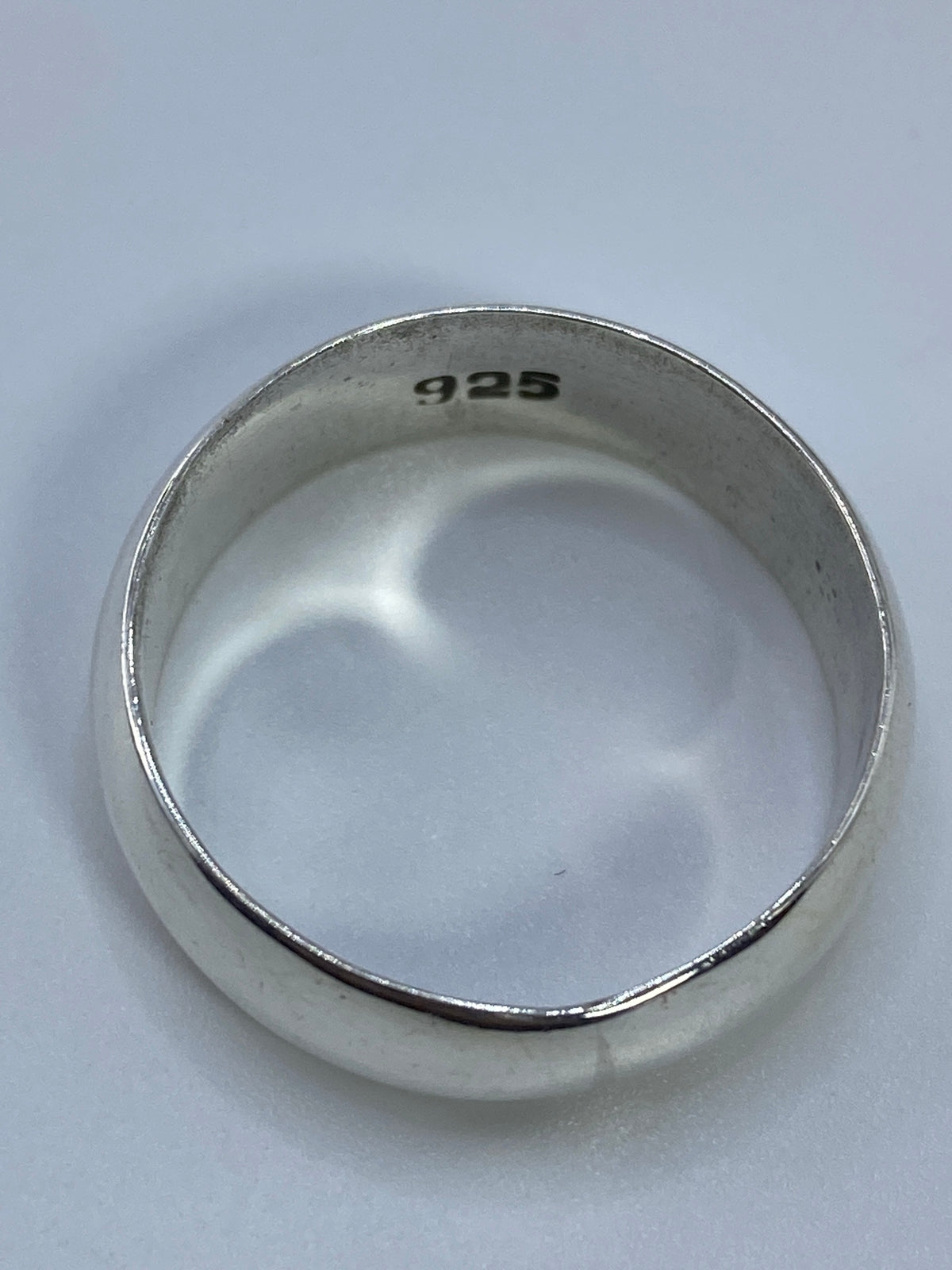 Anillo sobre fondo blanco destacando el grosor y brillo de la plata