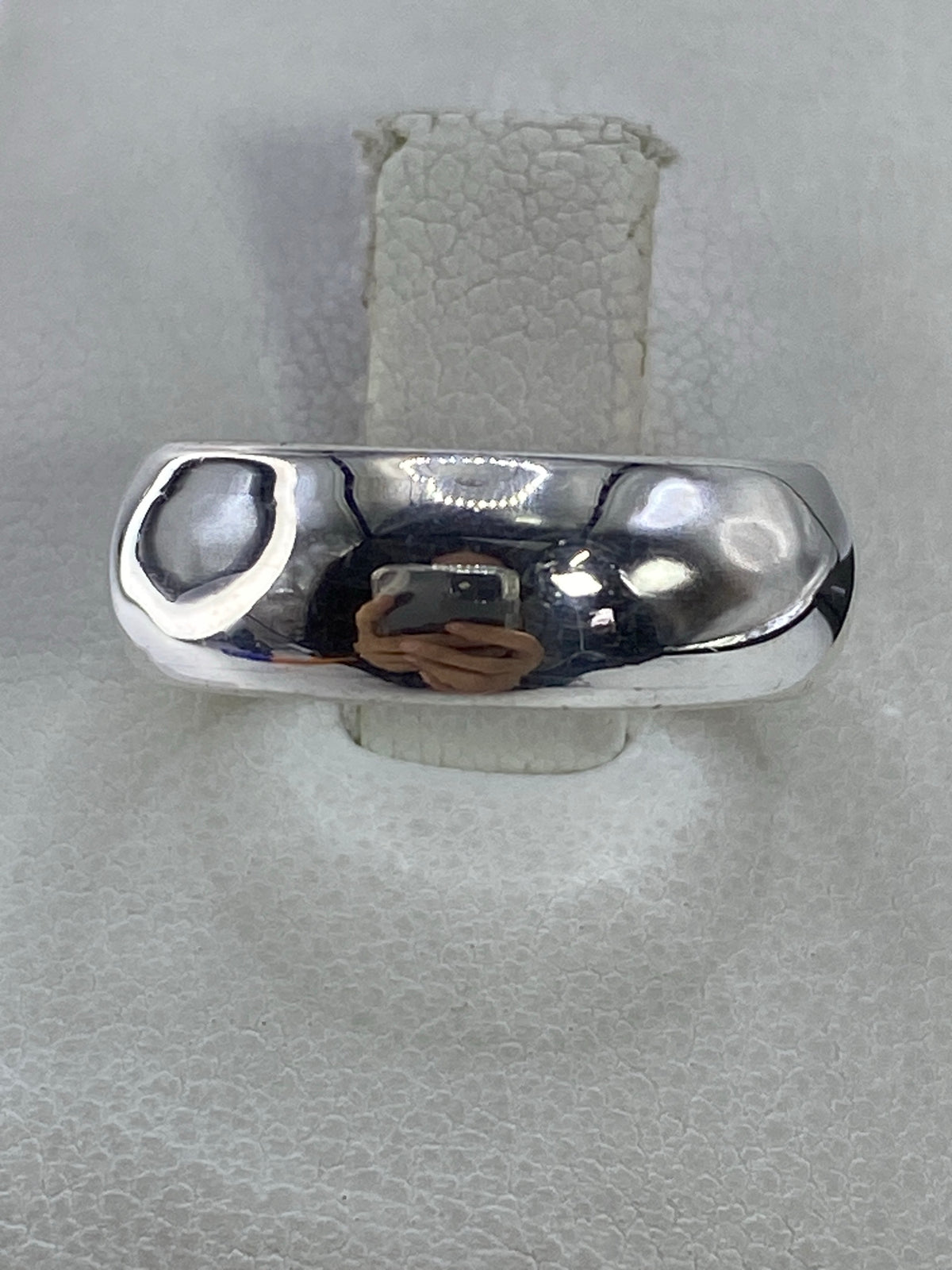 Anillo de plata 925 minimalista pulido en la mano, vista superior