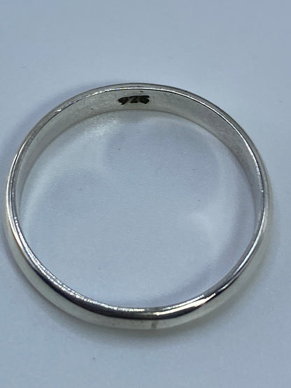 Anillo en dedo con luz natural reflejándose en la plata pura