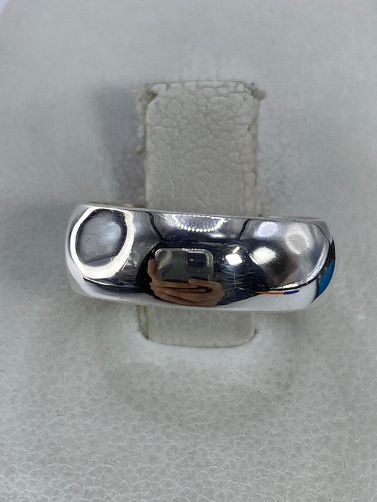 Anillo de plata 925 pulido, banda minimalista, en la mano sobre fondo blanco