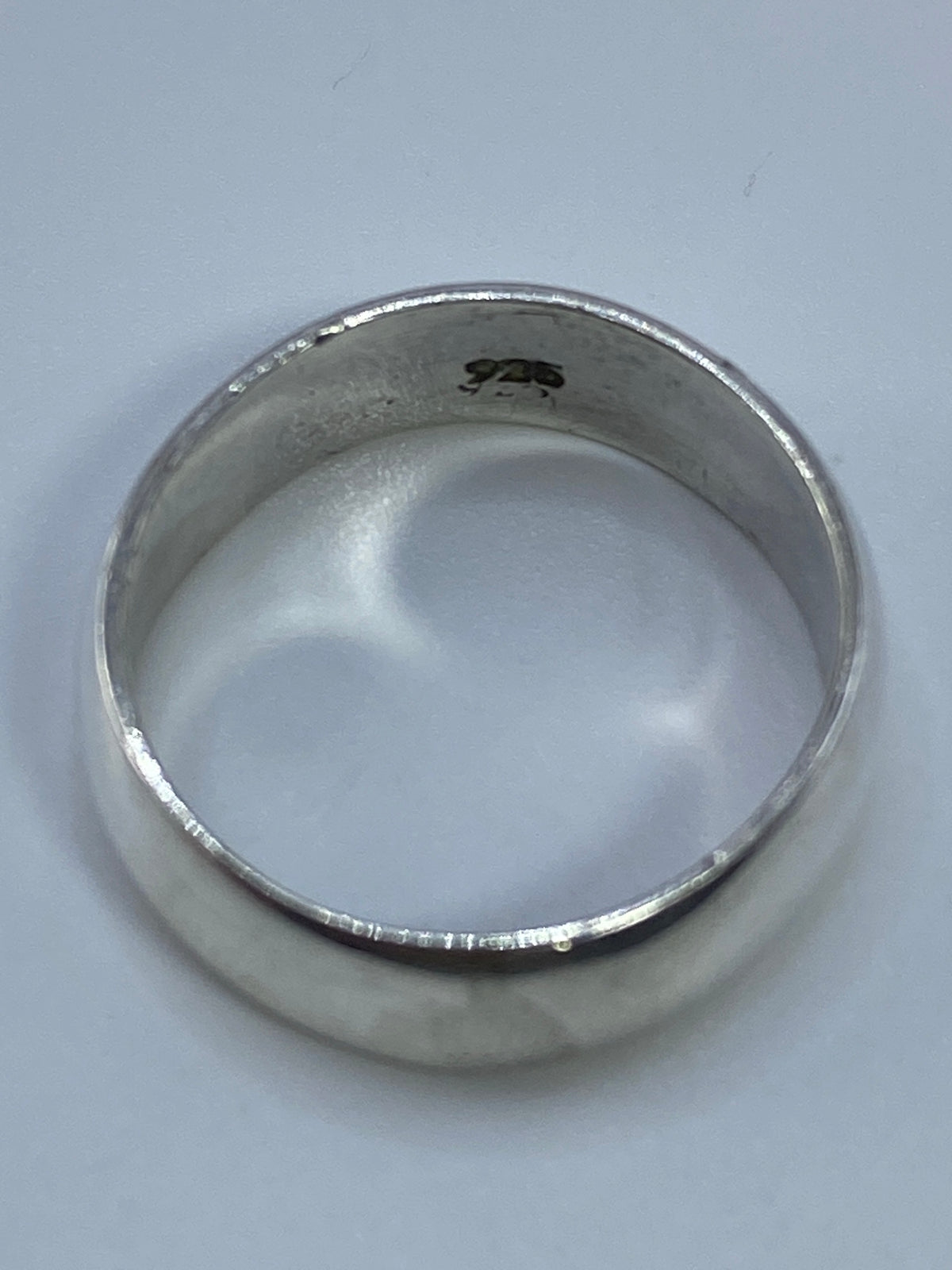 Anillo de plata sobre fondo blanco mostrando el peso y la calidad del material
