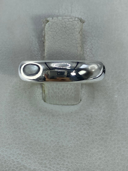 Anillo de plata 925 liso pulido en la mano sobre fondo claro