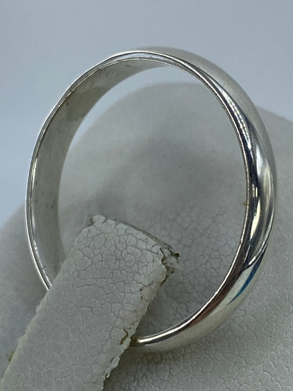 Anillo de plata en el dedo anular con luz reflejada en el pulido