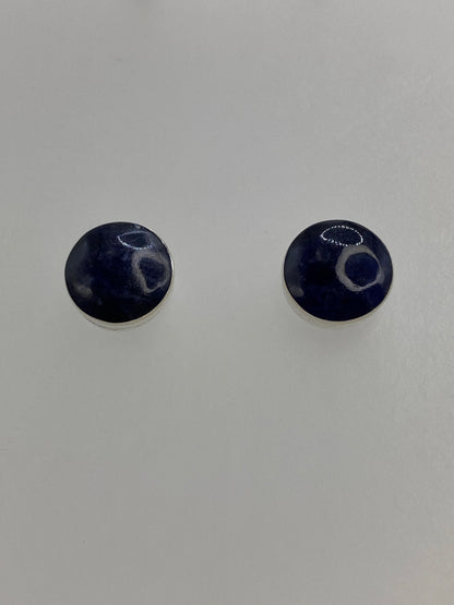 Detalle de un arete mostrando la piedra lapislázuli morada engastada en plata 950