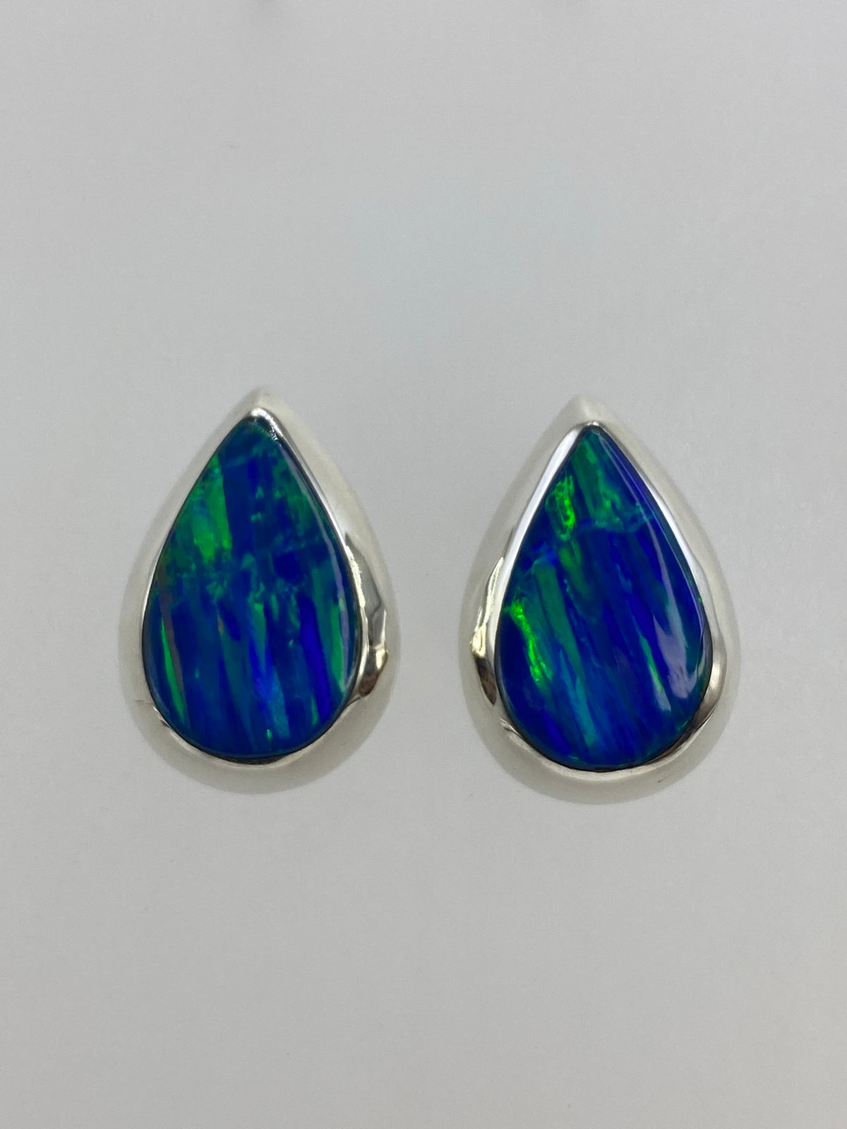 Aretes de plata con ópalo de fuego azul, vista frontal del par