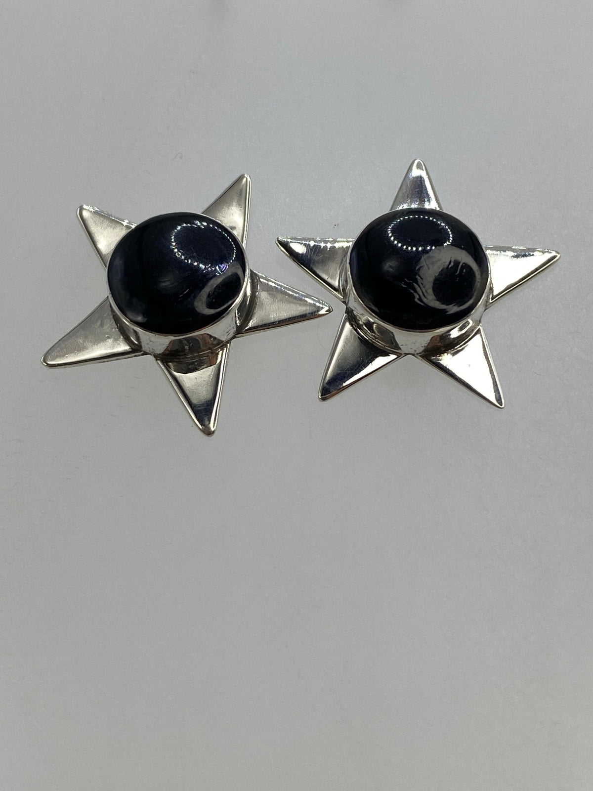 Arete individual de estrella de plata brillante con ónix negro lustrosa