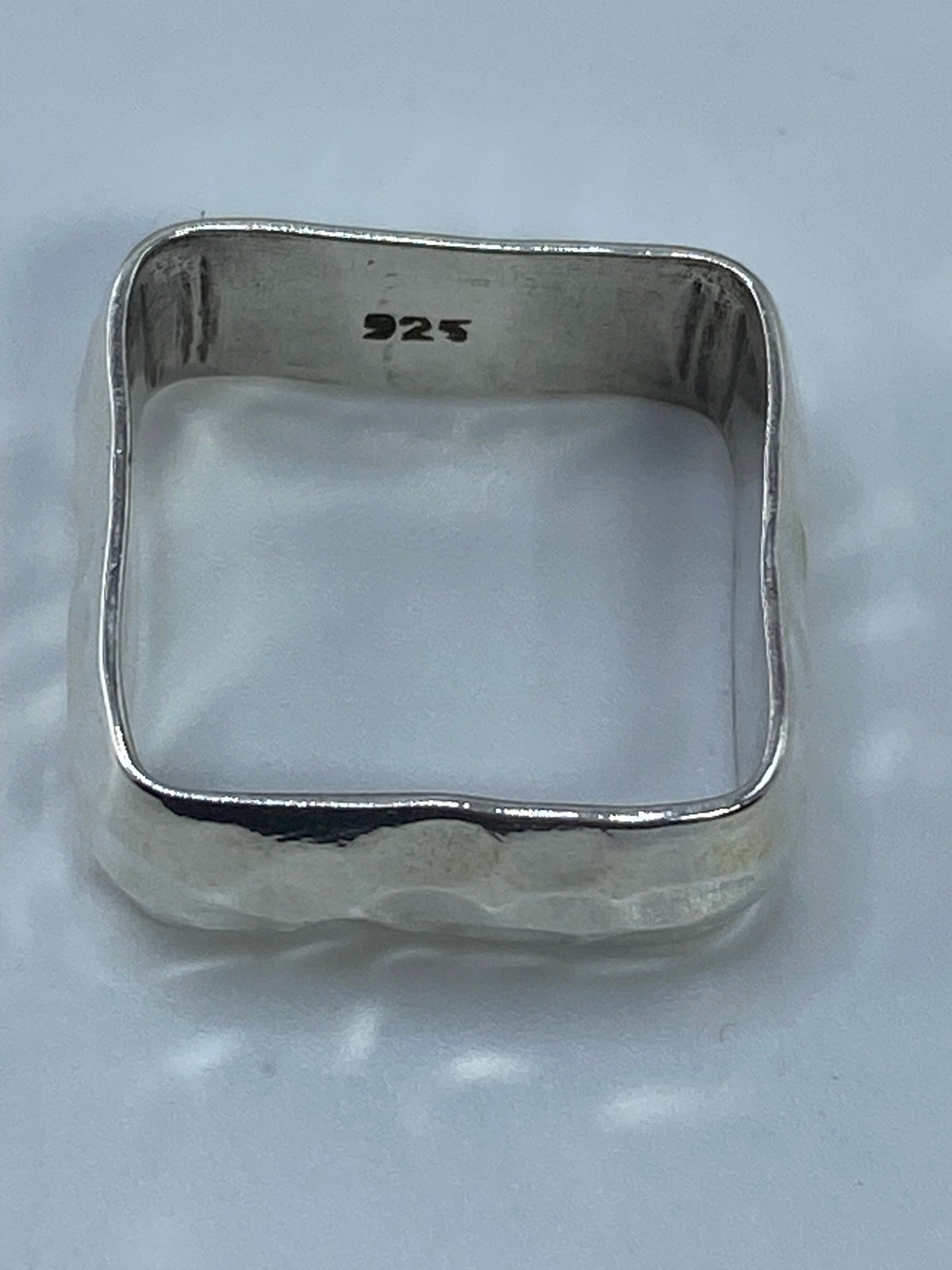 Anillo de plata minimalista sobre fondo blanco
