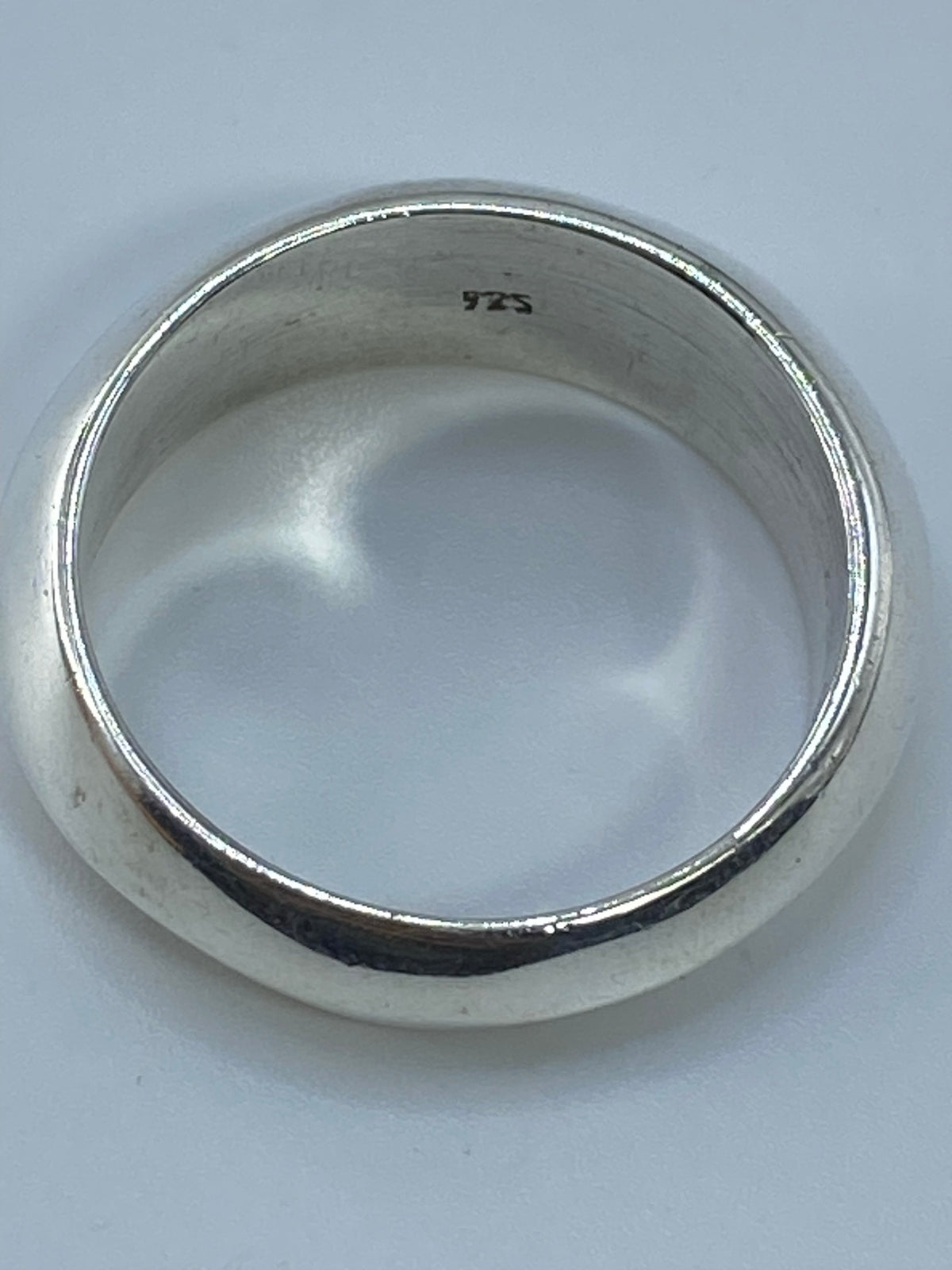 Anillo de plata en la mano, demostrando el acabado pulido brillante