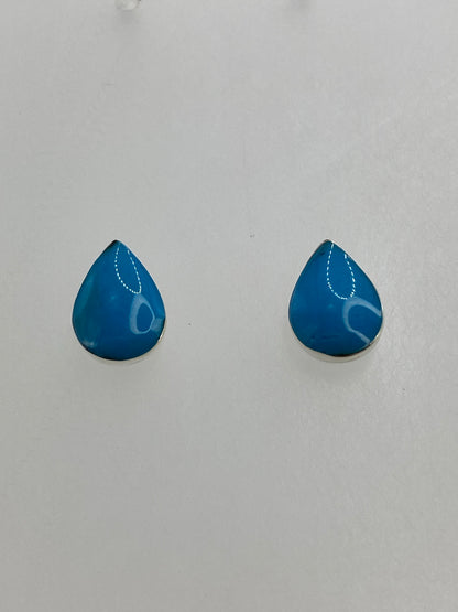 Detalle de los aretes mostrando el engaste de coral a mano en plata 950