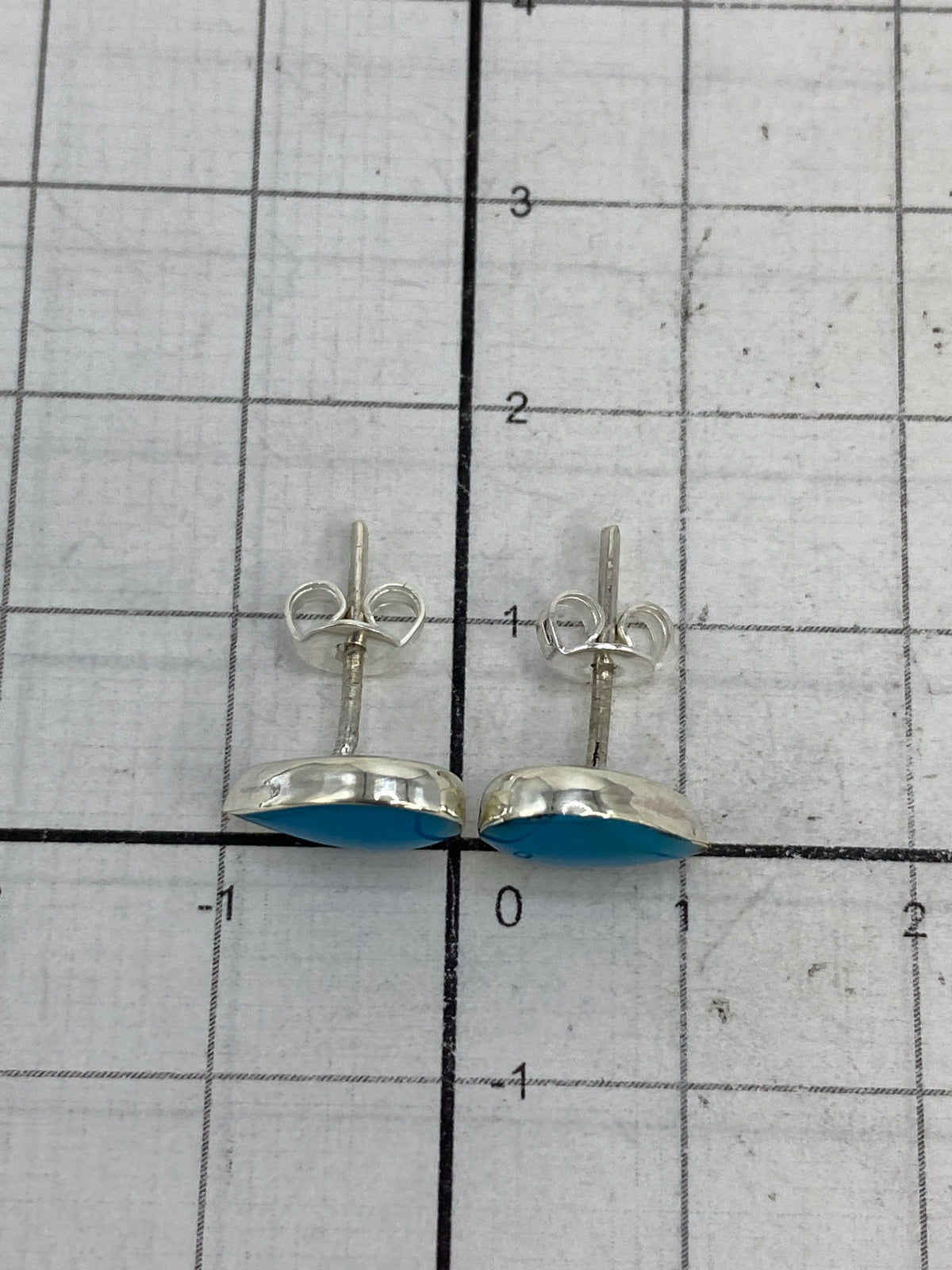 Aretes en la balanza mostrando peso total de 1.28 g con sello de Quinto 950 visible