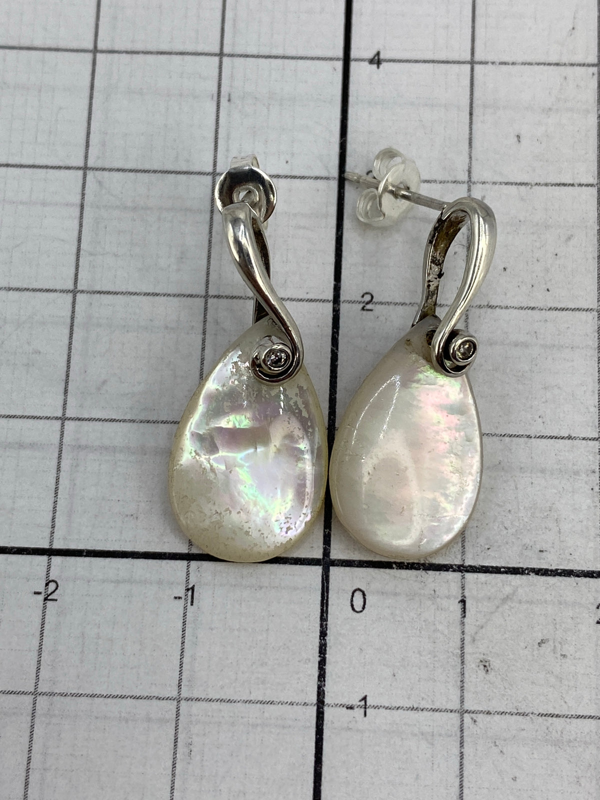 Aretes en la mano mostrando el tamaño (2.6 cm largo) y la proporción