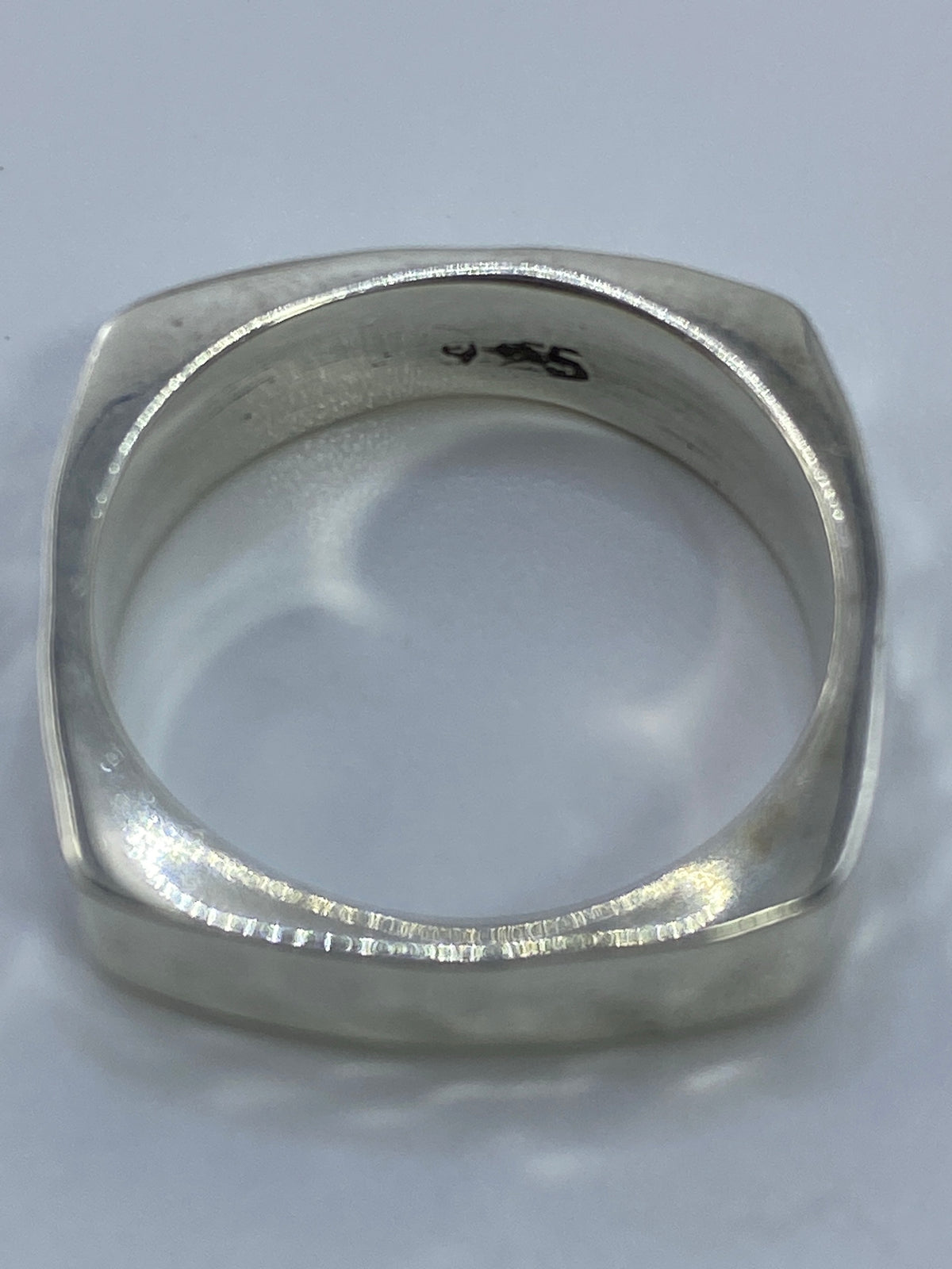 Anillo cuadrado de plata sobre balanza digital mostrando peso de 5.92 gramos