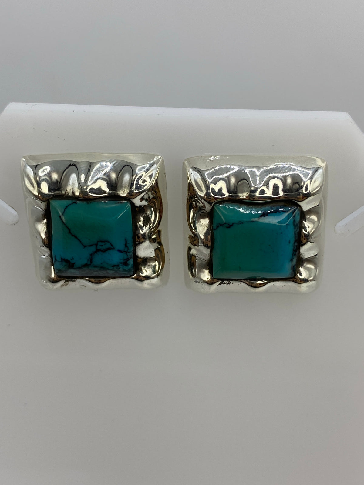 Aretes de turquesa en plata engastados a mano, vista frontal del par completo
