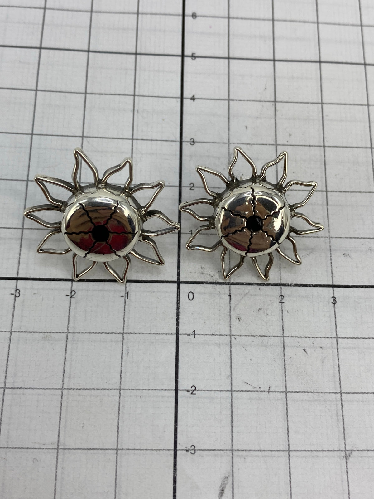 Medición de los aretes en regla milimétrica, largo 2.8 cm ancho 2 cm