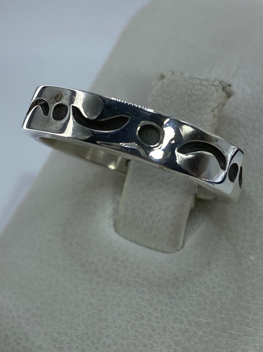Anillo de plata sin piedras con patrón de relieve, vista lateral mostrando el pulido brillante