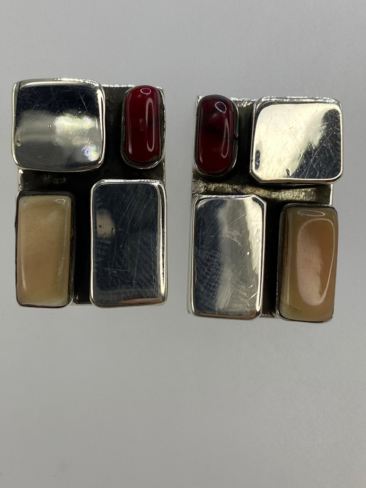 Aretes de plata con coral en una regla centimétrica, lado del cierre