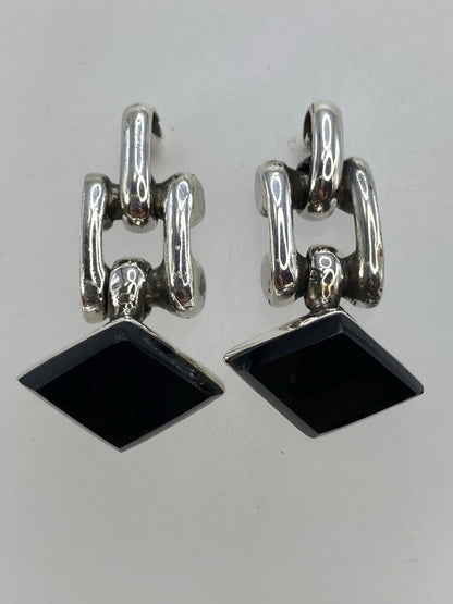 Detalle de los aretes mostrando el engaste de ónix negro y el brillo de la plata 925
