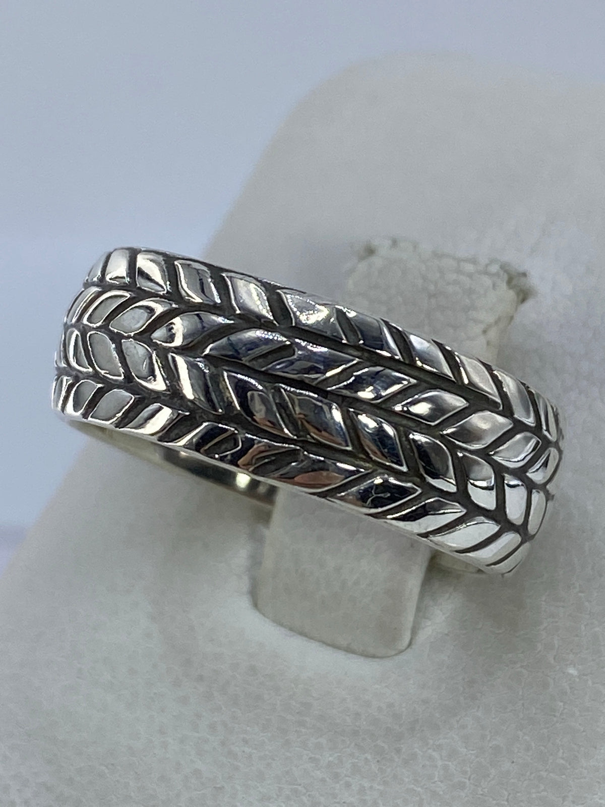 Detalle lateral del anillo mostrando el tejido de cuatro bandas y el acabado pulido