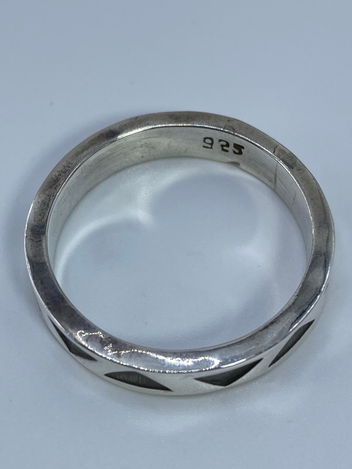 Anillo sobre fondo blanco en posición plana, revelando el patrón completo de triángulos