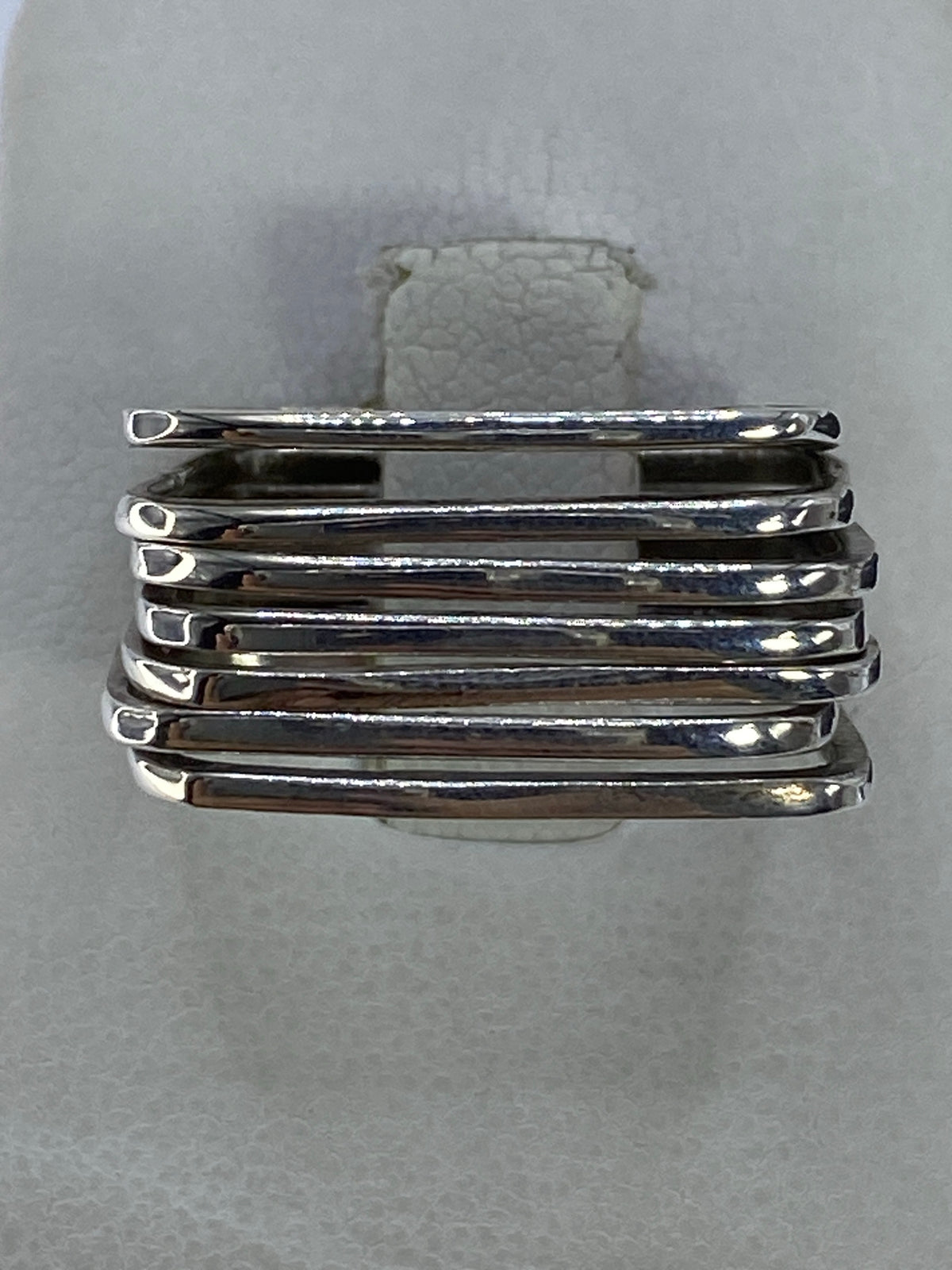 Anillo de plata con bandas paralelas pulidas en la mano de una persona