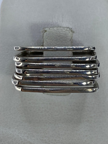 Anillo de plata con bandas paralelas pulidas en la mano de una persona