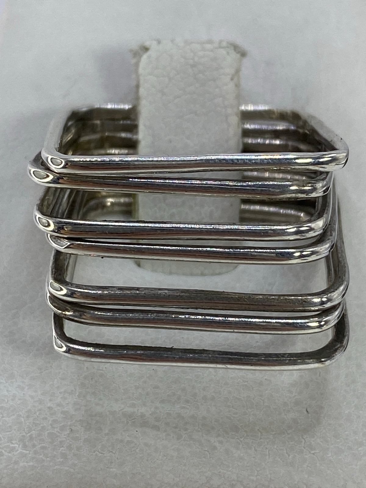 Anillo semanario de plata 925 con bandas paralelas sobre fondo blanco