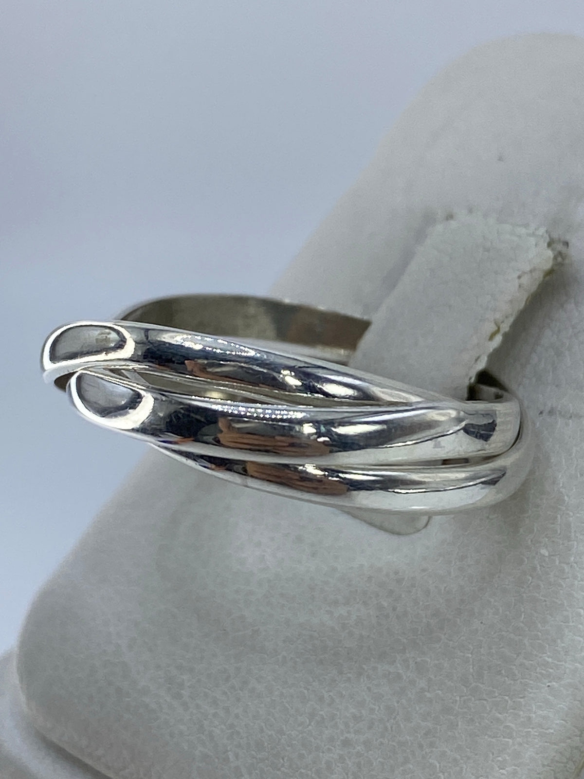Anillo de 3 bandas en mano, mostrando el diseño minimalista y el flujo de las líneas