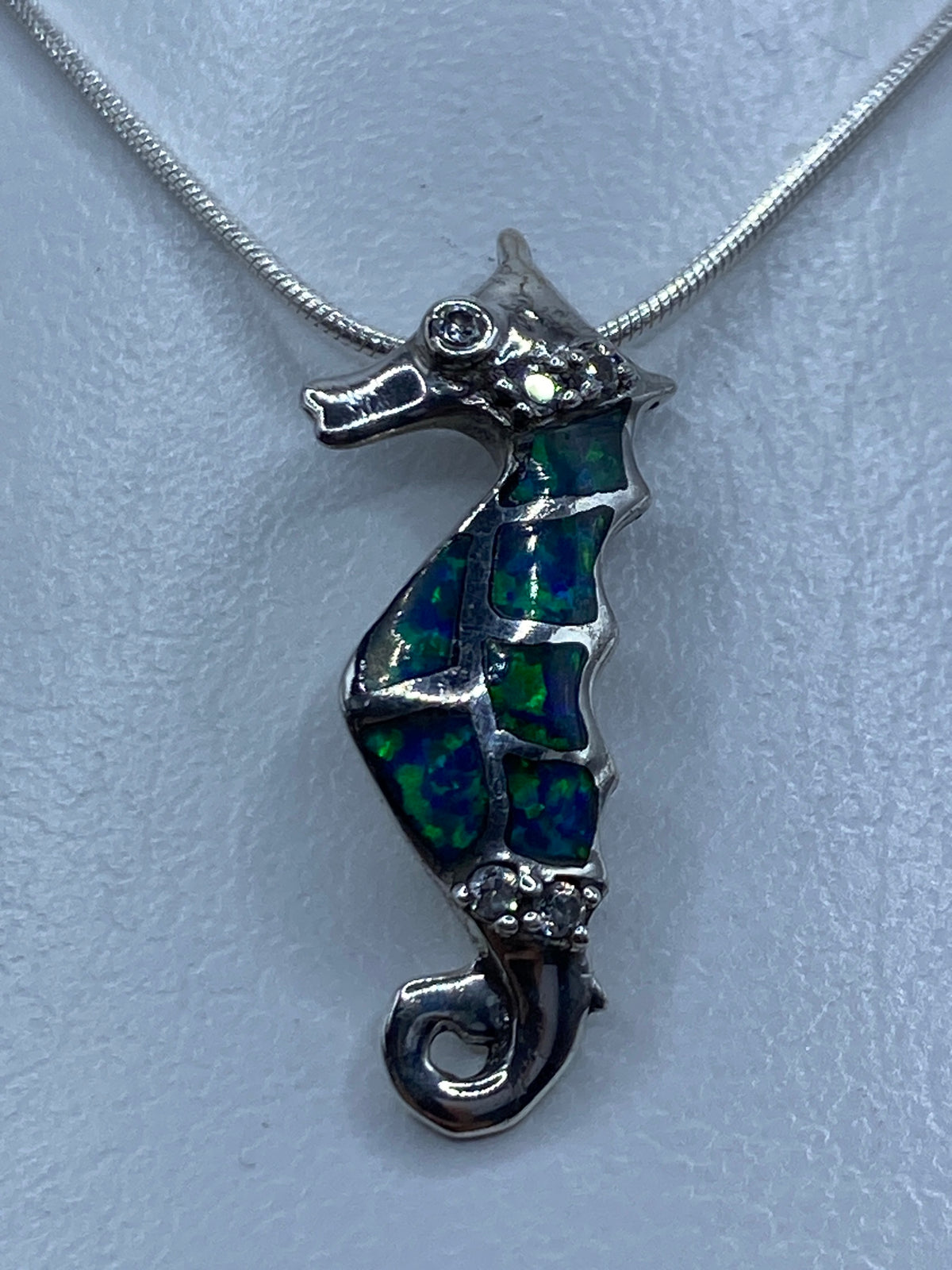 Dije caballito de mar en plata 925 con ópalo de fuego azul, colgado en cadena de plata