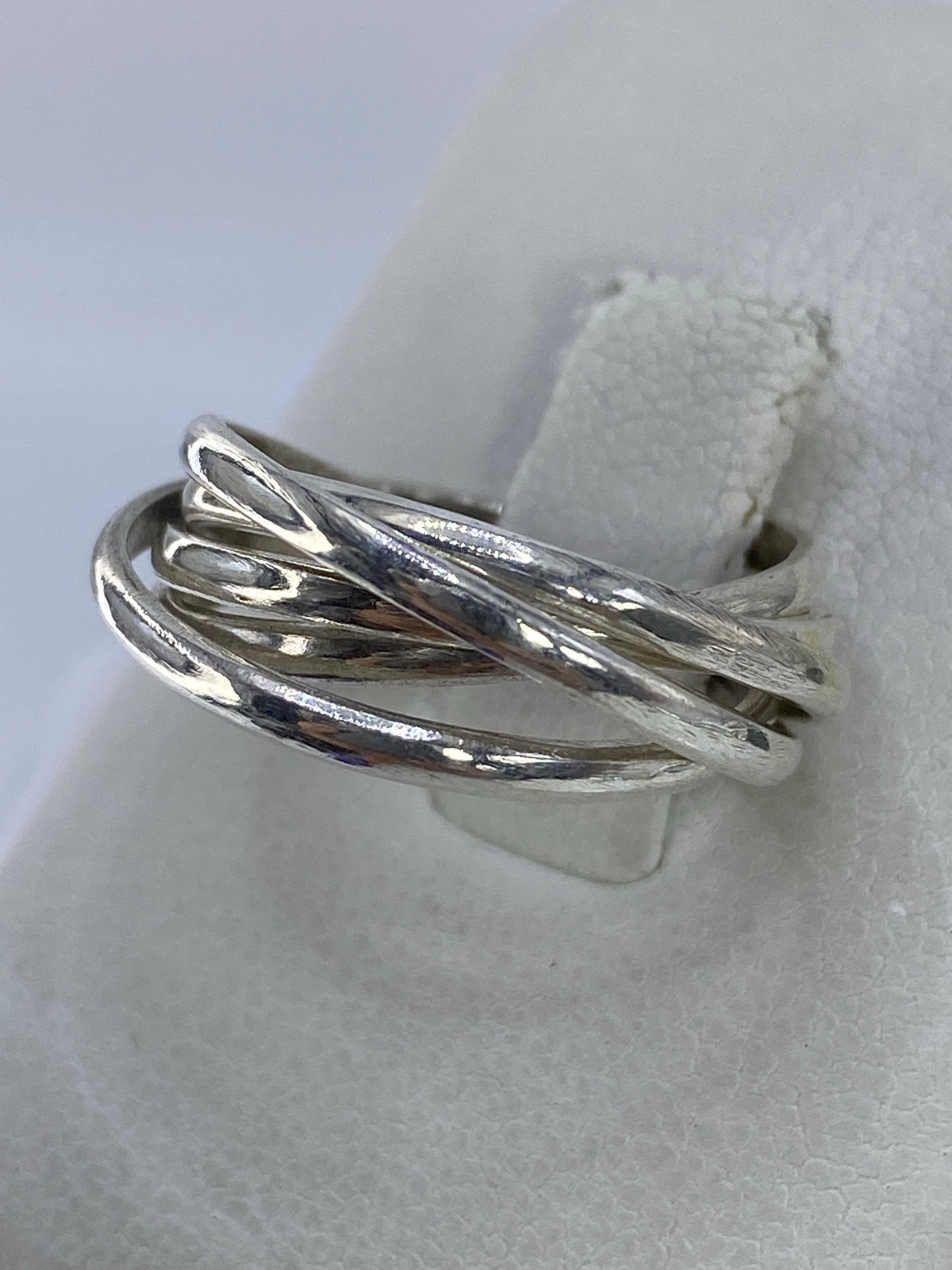 Detalle lateral del anillo de cinco bandas mostrando cómo se entrelazan los hilos de plata