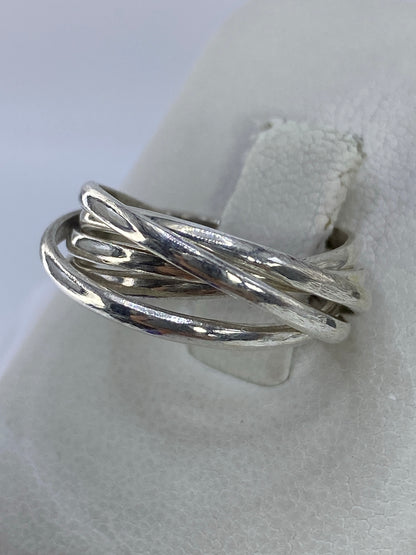 Detalle lateral del anillo de cinco bandas mostrando cómo se entrelazan los hilos de plata