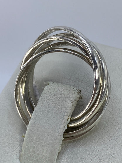 Anillo cinco bandas colocado en la mano mostrando la geometría fluida del diseño