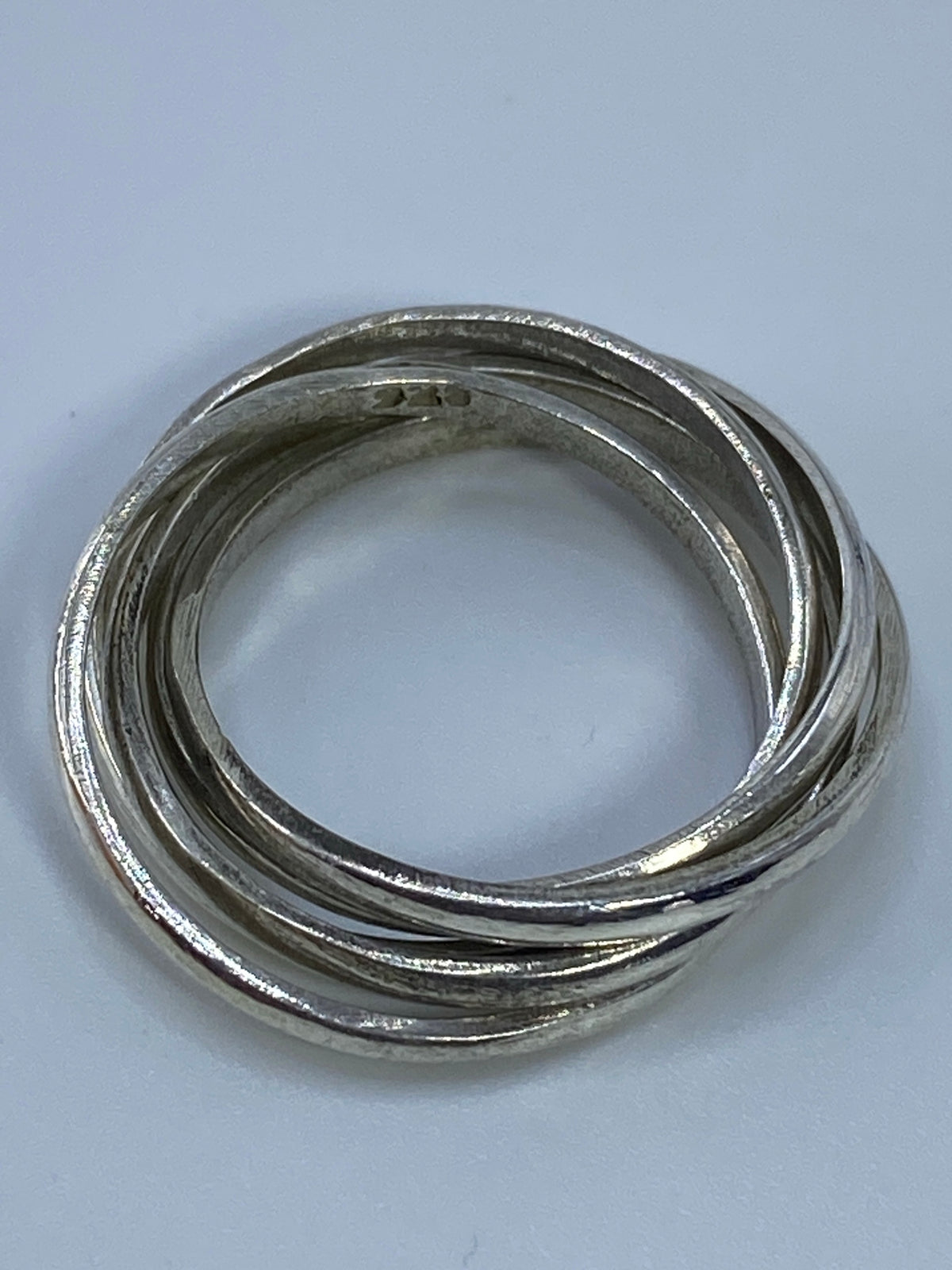 Fotografía del anillo sobre fondo blanco evidenciando el pulido y acabado del Quinto 925