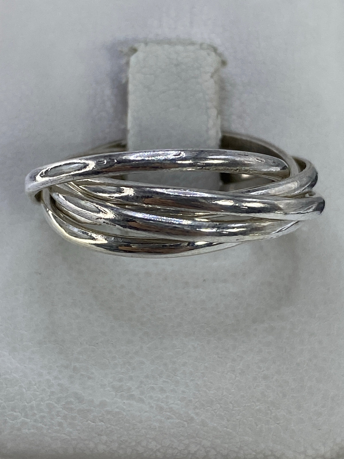 Anillo de plata 925 con 5 bandas entrelazadas visto desde arriba sobre fondo blanco