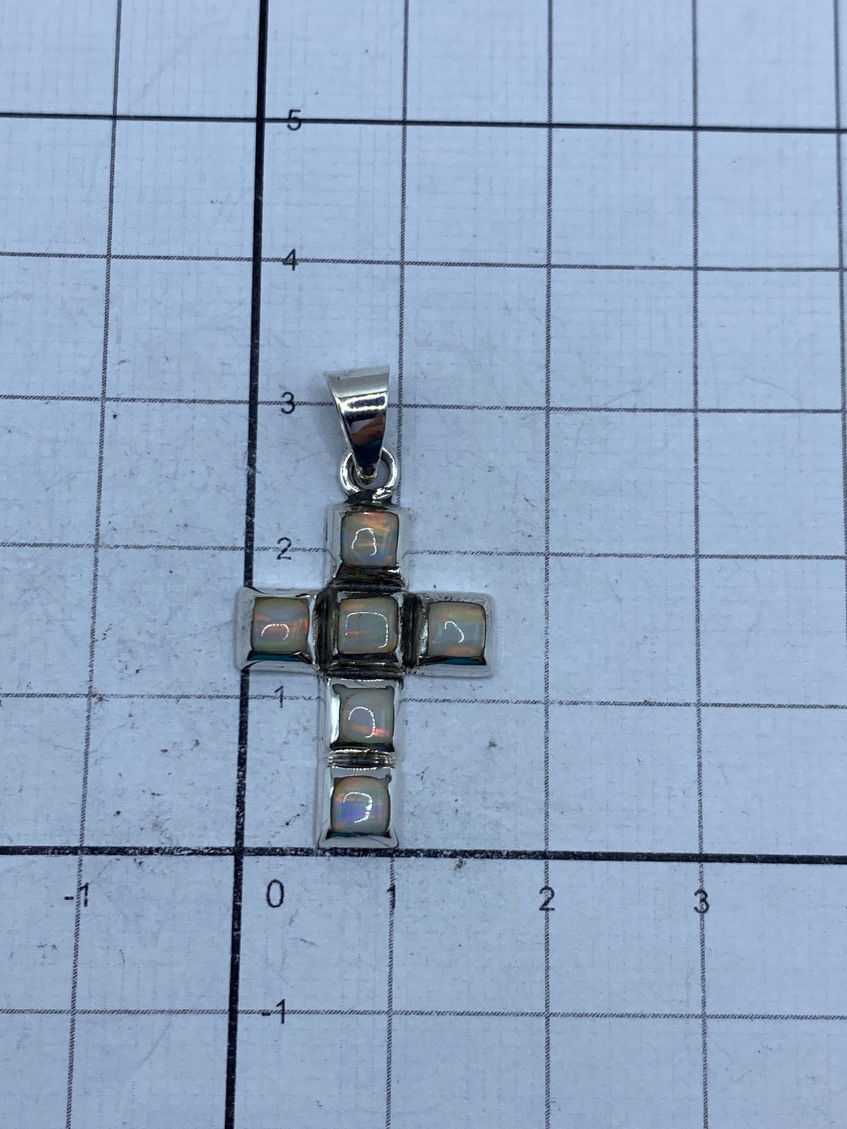 Medición del dije en regla: 3.5 cm de largo, escala real