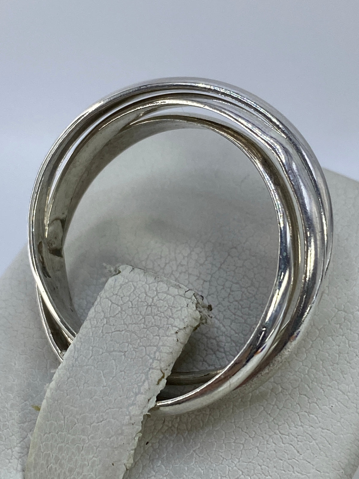 Anillo puesto en el dedo mostrando cómo las bandas se cruzan