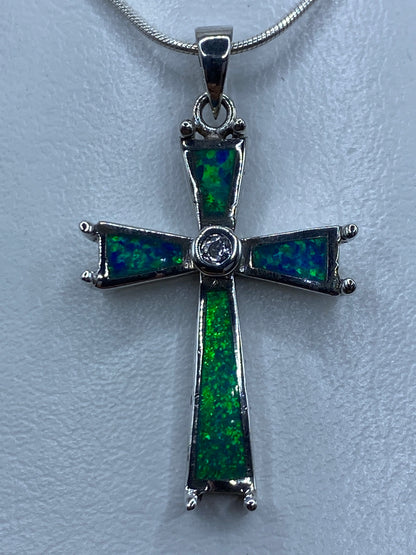 Dije cruz de plata 925 con ópalo de fuego azul colgado de cadena plateada