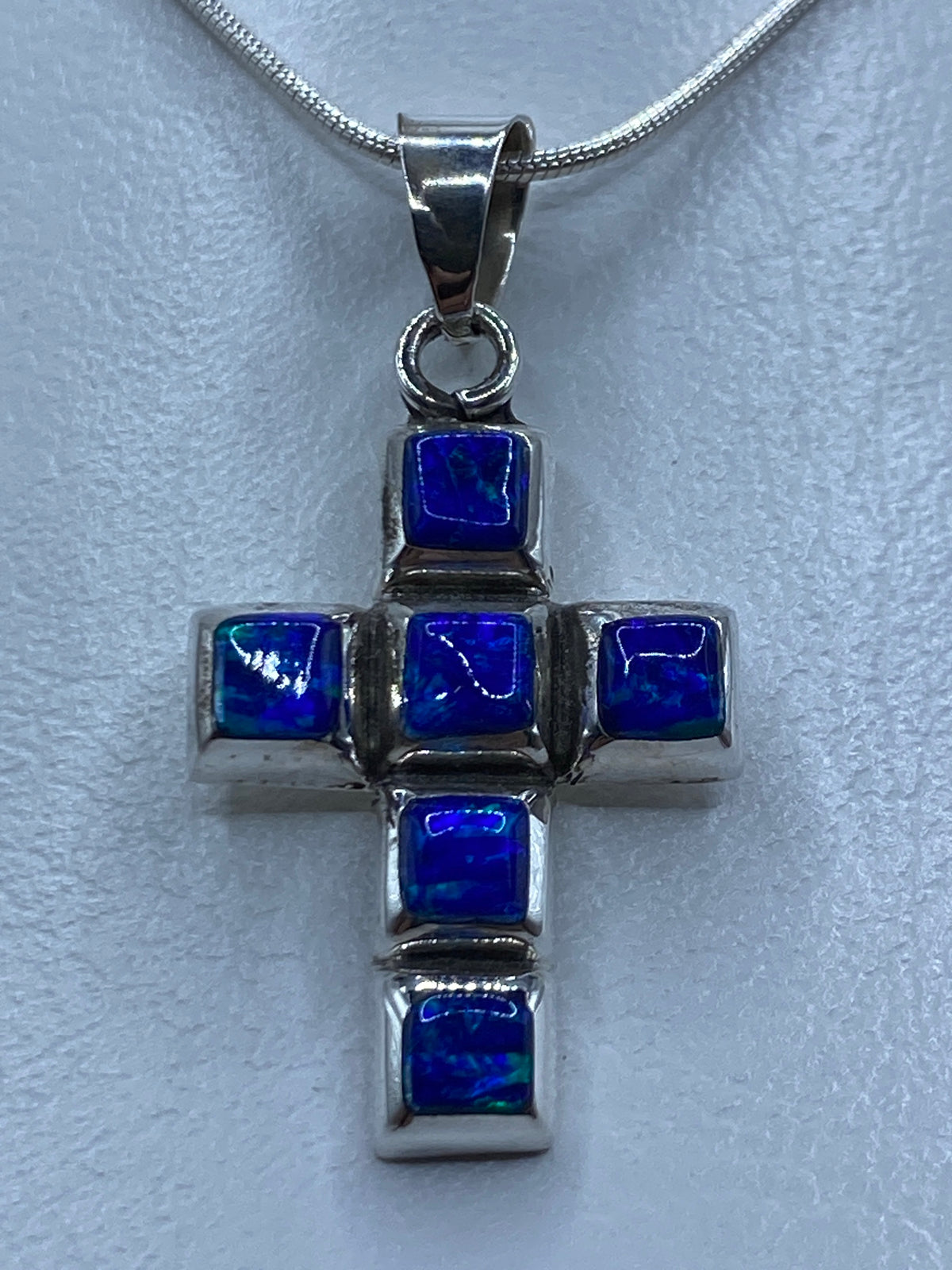 Dije cruz de plata 950 con ópalo de fuego azul, colgando de cadena