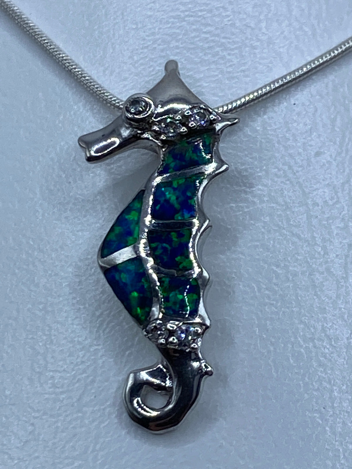 Dije caballito de mar en plata 925 con ópalo de fuego azul en cordón de plata, vista frontal
