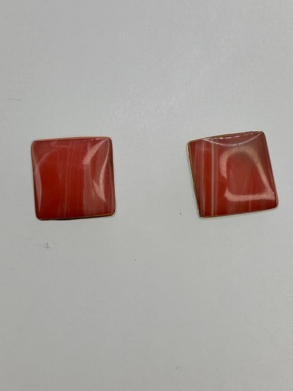 Vista frontal de los aretes de coral rosa con presilla de tuerca