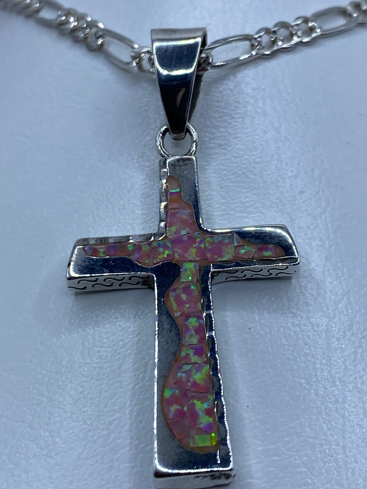 Cruz de plata con incrustación de ópalo rosa — vista frontal mostrando el patrón único de la piedra