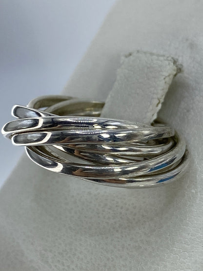 Anillo de plata entrecruzado en la mano, mostrando el brillo pulido