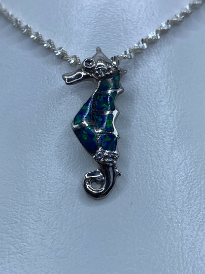 Dije de caballito de mar en plata 925 con ópalo azul y circonia blanca sobre cadena plateada