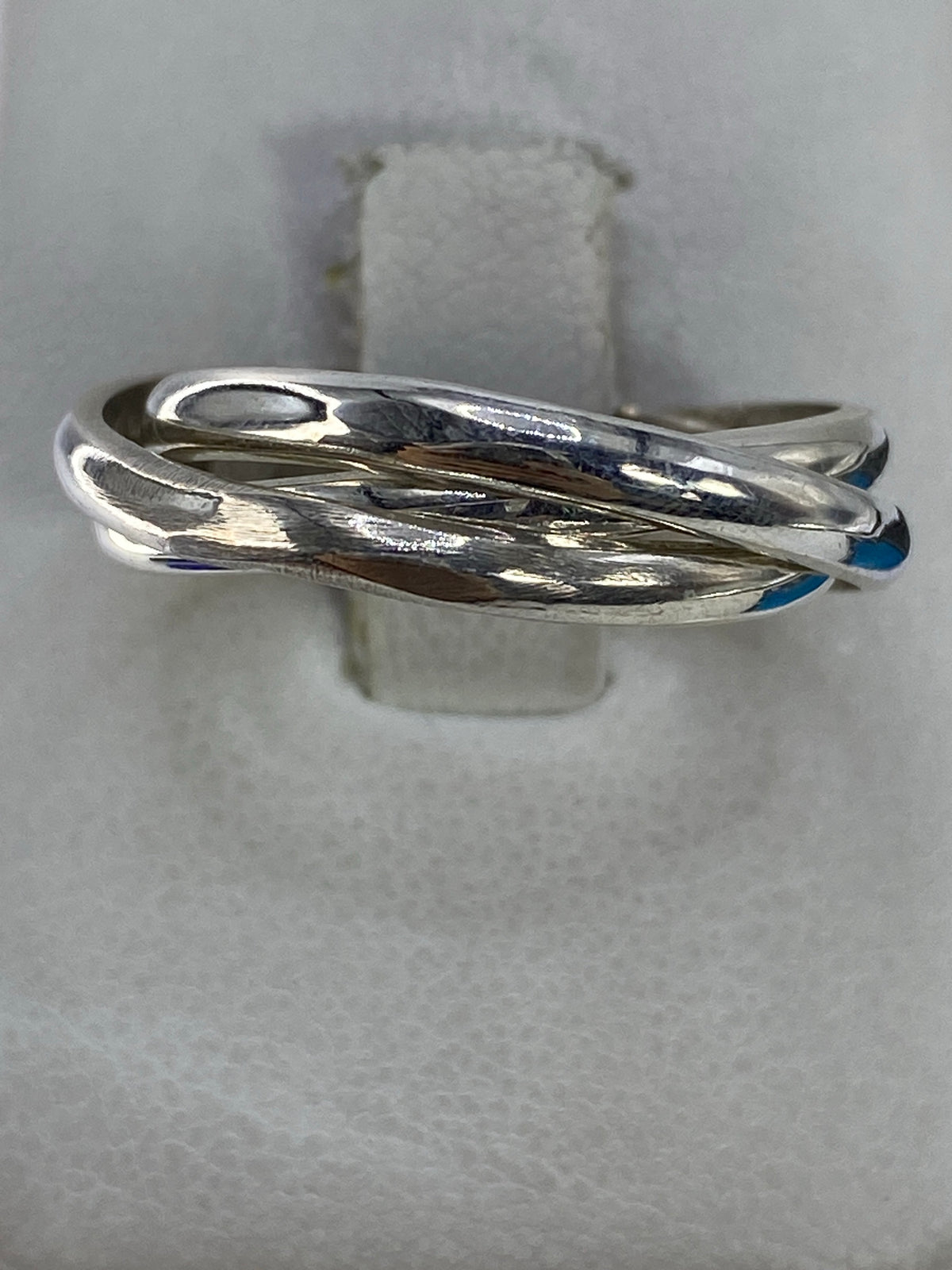 Anillo de plata 925 con tres bandas pulidas entrecruzadas en la mano