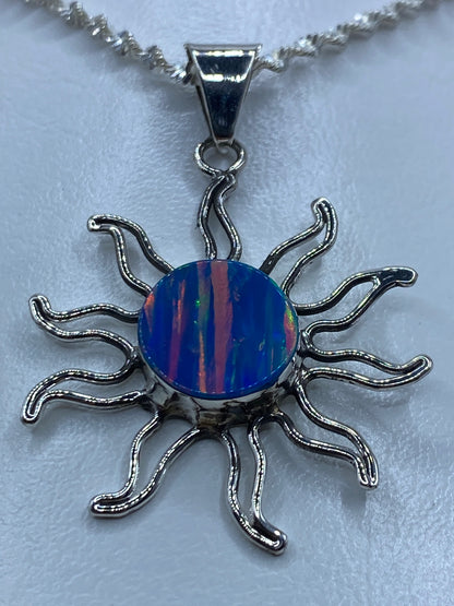 Detalle del ópalo de fuego azul dentro del dije solar de plata