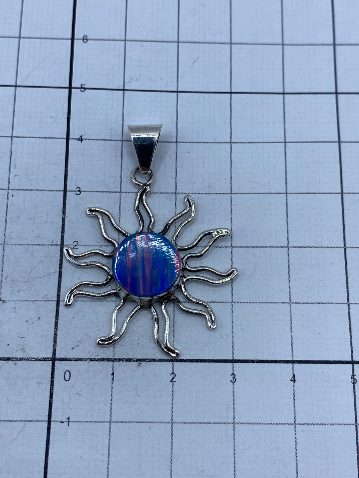 Dije solar en escala con regla, midiendo 4.2 cm de largo × 3 cm de ancho