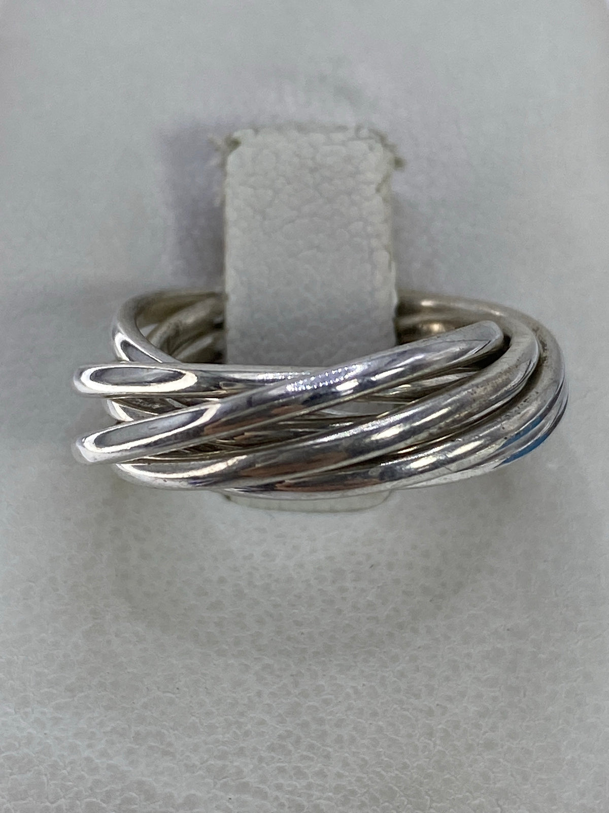 Anillo semanario de plata 925 con eslabones pulidos en la mano de una persona
