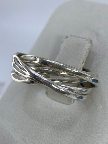Detalle lateral del anillo de bandas mostrando el entrelazado fluido