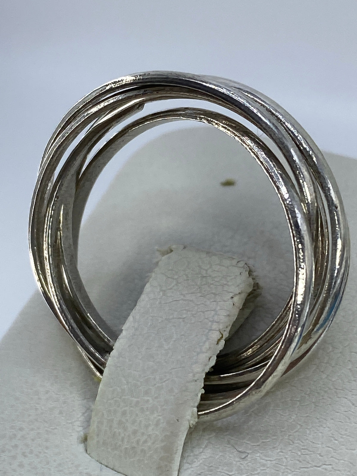 Anillo de 5 bandas puesto en dedo índice, con brillo de plata pura