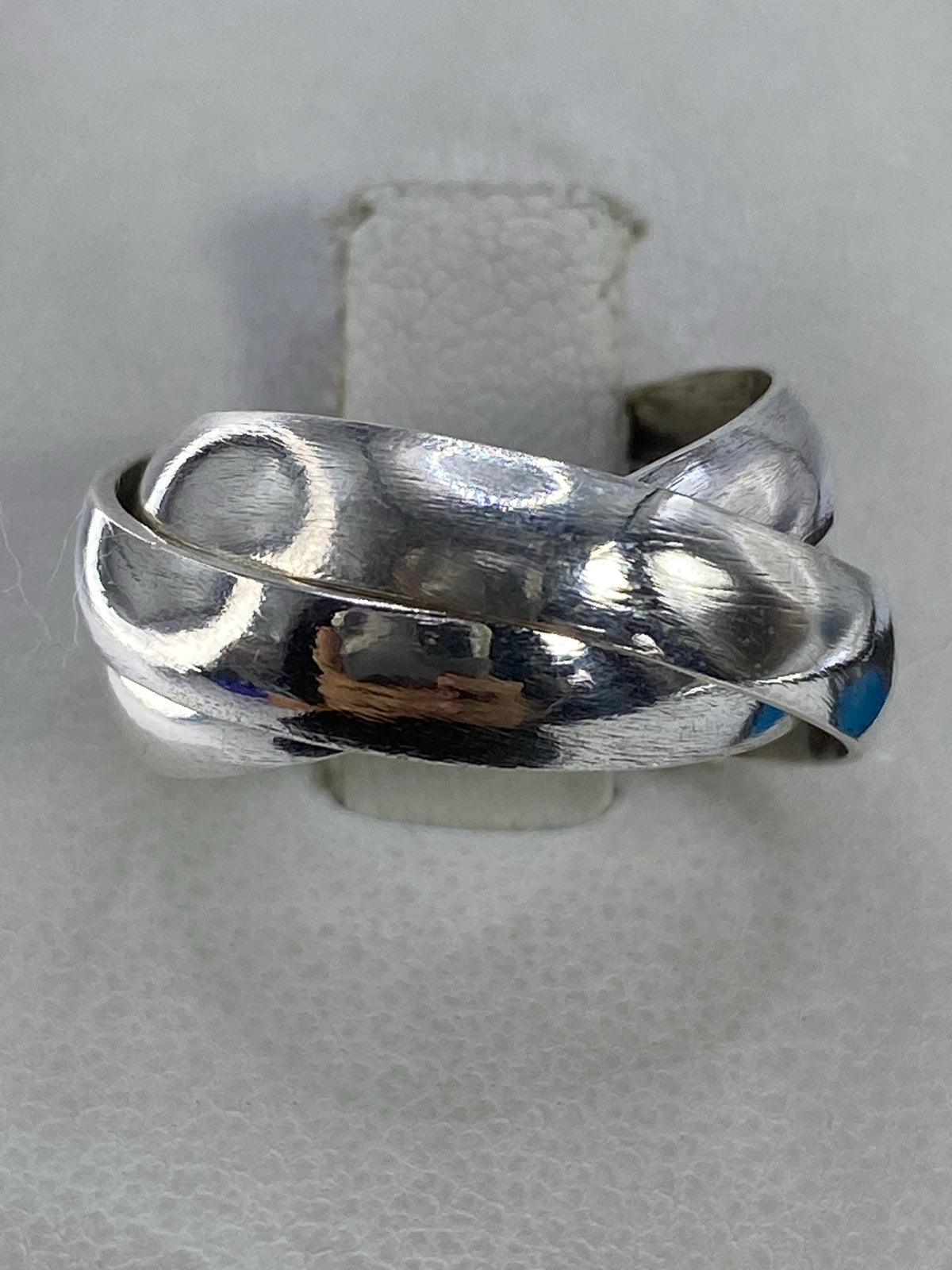 Anillo de tres bandas entrelazadas en plata 925 sobre fondo blanco